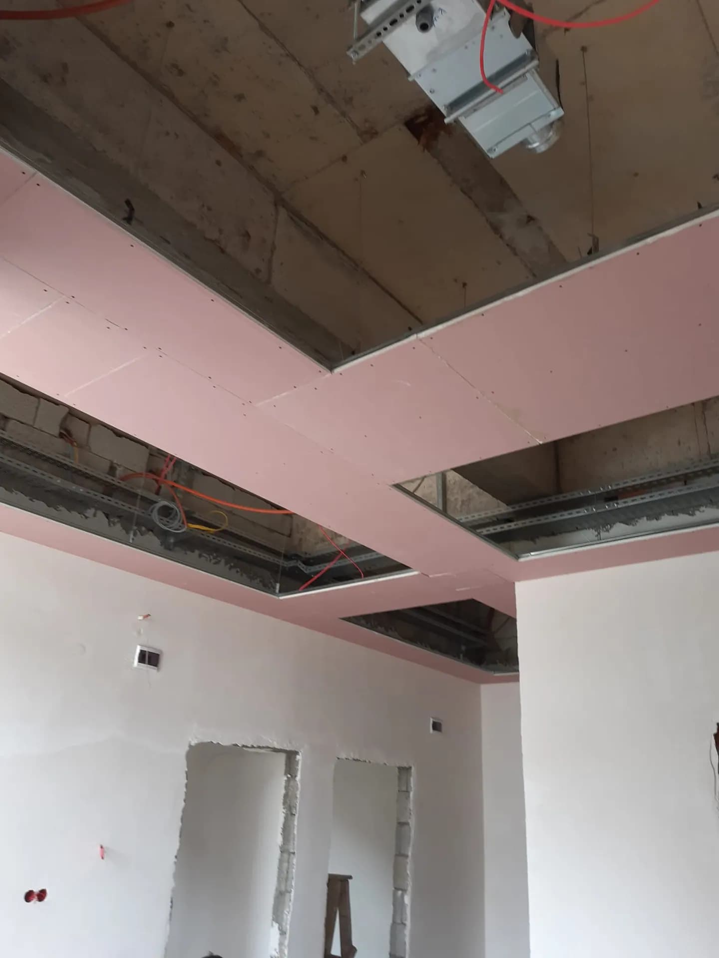 Metal taşıyıcı aksları görünen asma tavan kurulumu